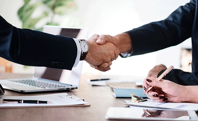arms in suit jackets shaking hands