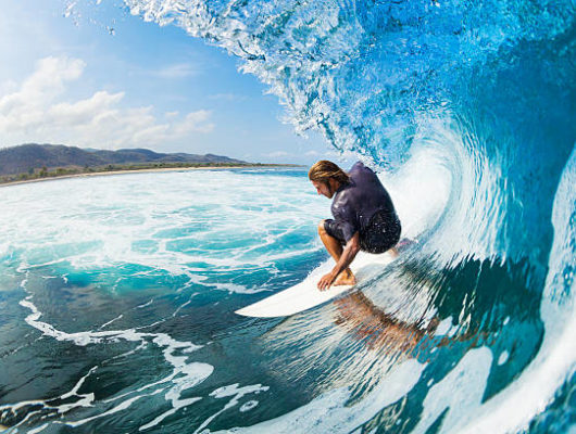 Surfer on Blue Ocean Wave in the Tube Getting Barreled