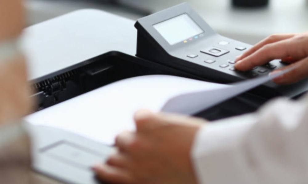 Man retrieving paper from office printer