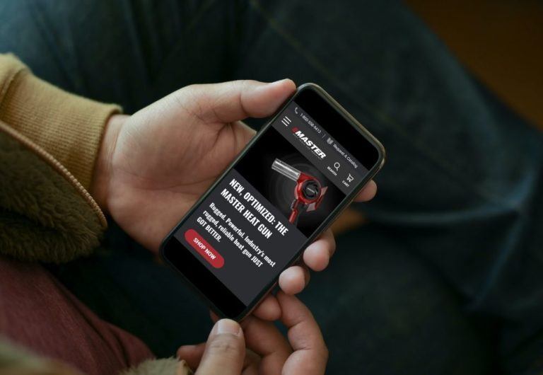 Man holding smartphone with MasterAppliance.com homepage on screen