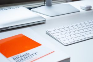 book on brand identity sitting next to computer on desk