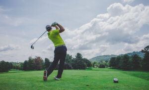 golfer green shirt swinging club