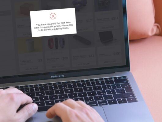 person shopping on laptop receiving a popup message about reaching the limit for number of items in their cart