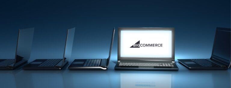 Row of laptops with one front-facing with BigCommerce logo on screen