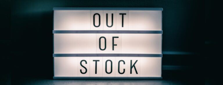White outdoor sign saying "Out Of Stock" against dark background