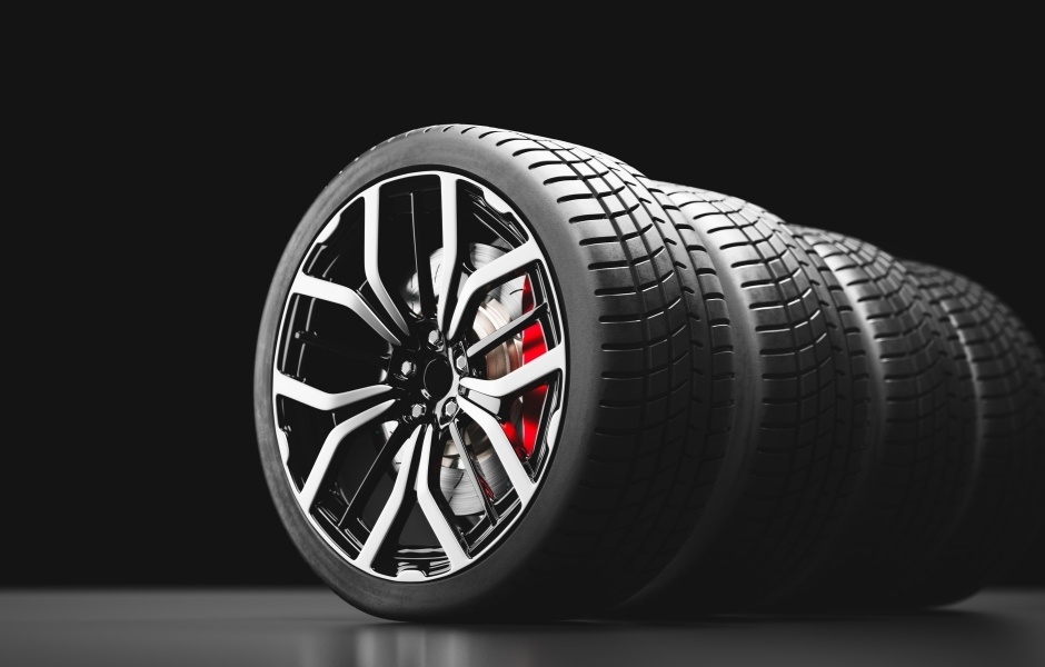 Row of tires with chrome wheels on dark, modern backround - BigCommerce Automotive Design and Development