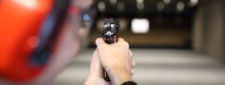 Person in Gun Range pointing gun at target