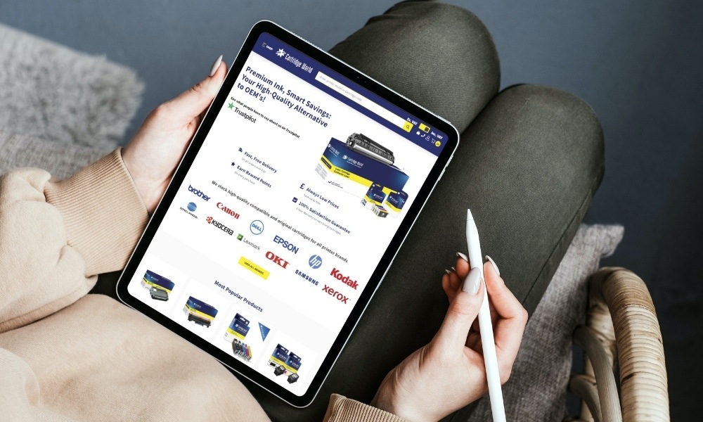 Woman on tablet holding stylus with CartridgeWorld.co.uk Homepage on Screen