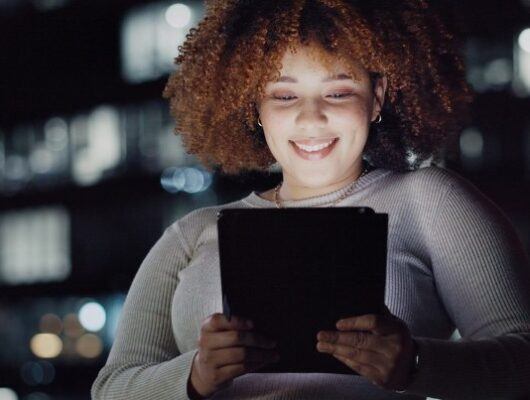Tablet, night balcony and relaxed woman reading and smiling, customer experience or ecommerce