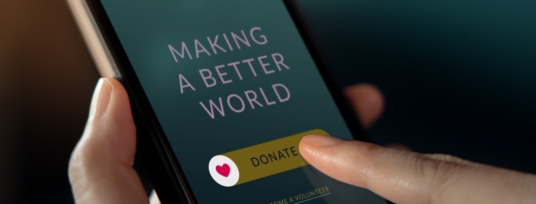 Person on mobile phone adding a donation at checkout - Roundup App BigCommerce