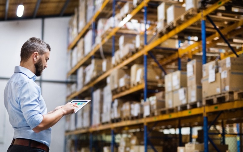 Man looking at table report in distribution warehouse - Enterprise SEO Ecommerce