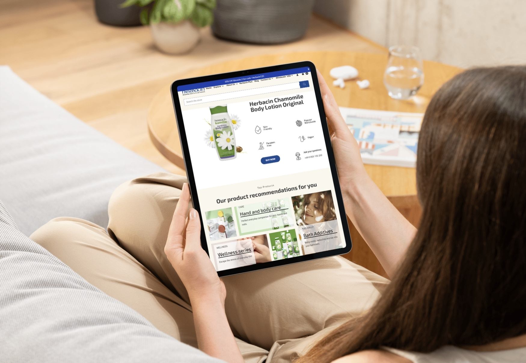 woman on couch with tablet showing HerbacinUSA.com homepage - BigCommerce design