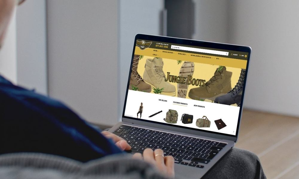 person on laptop with screen showing FatiguesArmyNavy.com homescreen