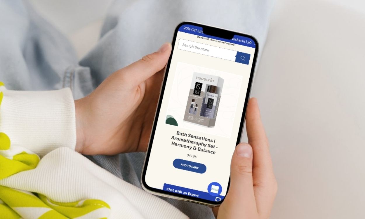 person holding smartphone with HerbacinUSA.com on the screen