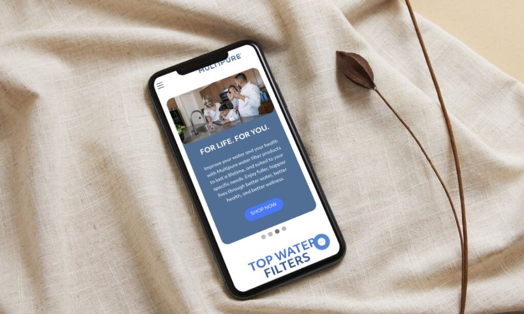Smartphone against beige fabric showing homepage for multipure.com - BigCommerce design