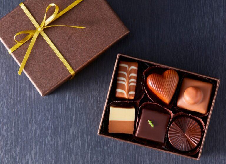Open gift box with bow showing chocolate assortment inside - Food and beverage ecommerce bigcommerce
